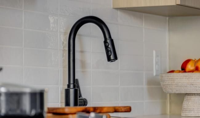 a kitchen with a black faucet and a black handle